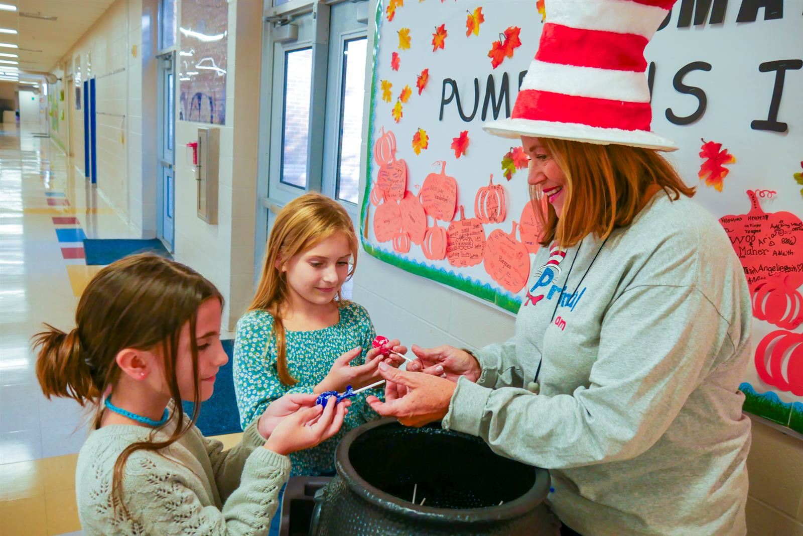 principal handing candy to two girls